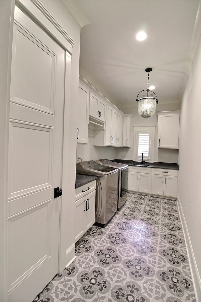 kitchen featuring separate washer and dryer, white cabinetry, sink, decorative light fixtures, and a notable chandelier