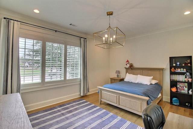 bedroom with a chandelier, crown molding, and light hardwood / wood-style flooring