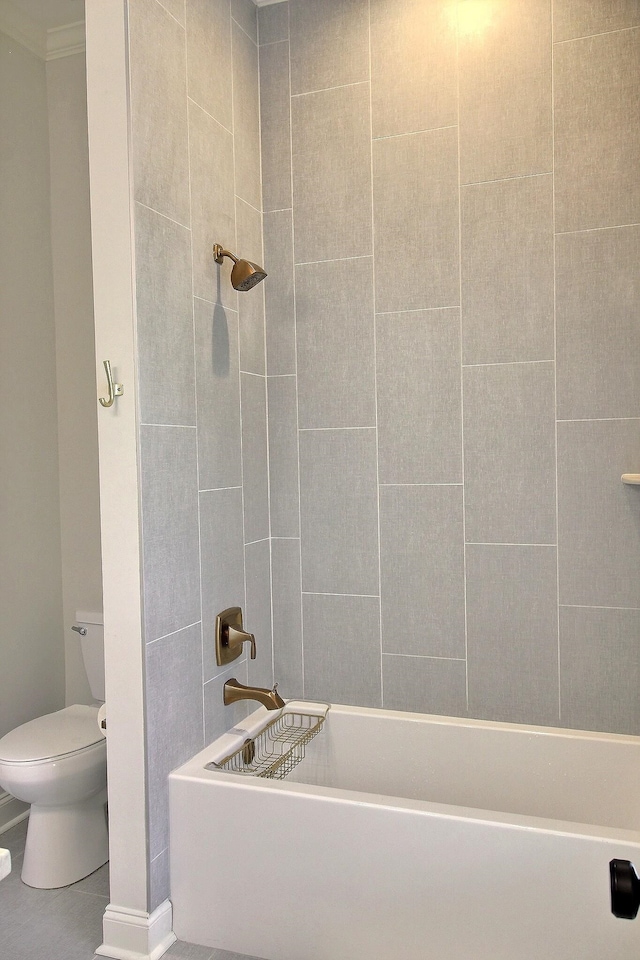 bathroom featuring tiled shower / bath and toilet