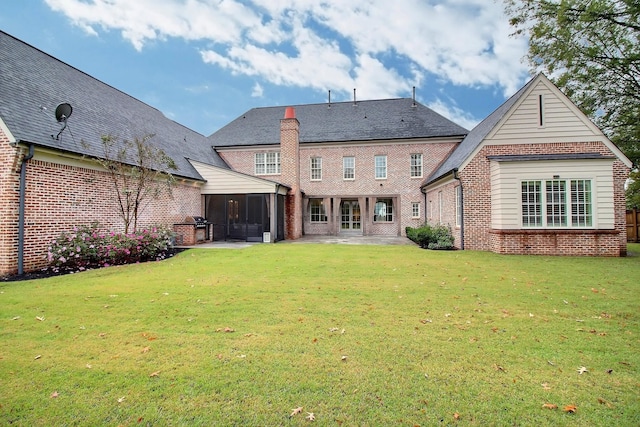 back of house featuring a patio area, a sunroom, and a yard