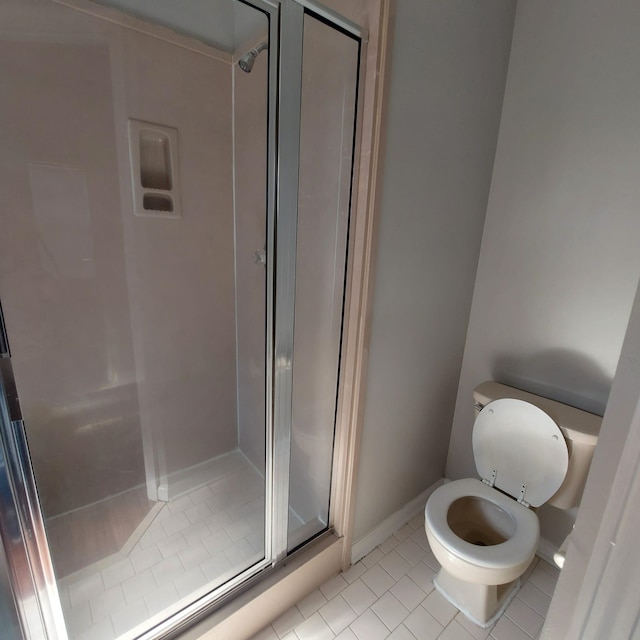 bathroom featuring walk in shower, tile patterned flooring, and toilet