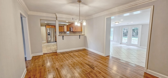 kitchen featuring light wood-type flooring, stainless steel appliances, kitchen peninsula, and backsplash