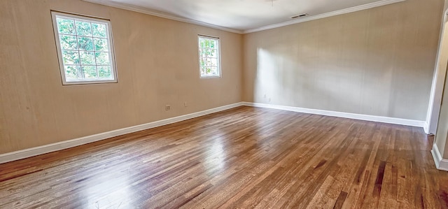 empty room featuring hardwood / wood-style floors, plenty of natural light, and crown molding