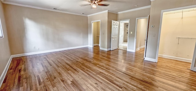 unfurnished bedroom featuring a closet, hardwood / wood-style floors, ceiling fan, and crown molding