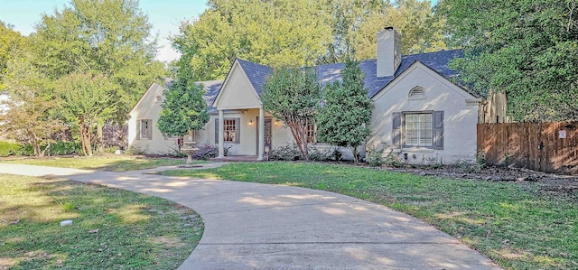 english style home featuring a front yard