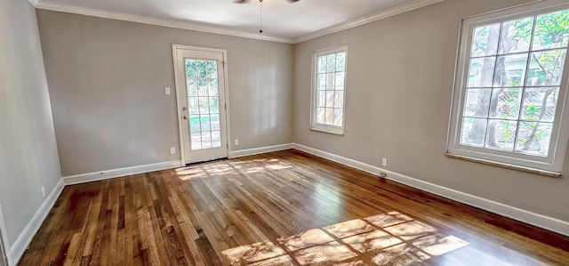 spare room with a wealth of natural light, crown molding, and hardwood / wood-style flooring