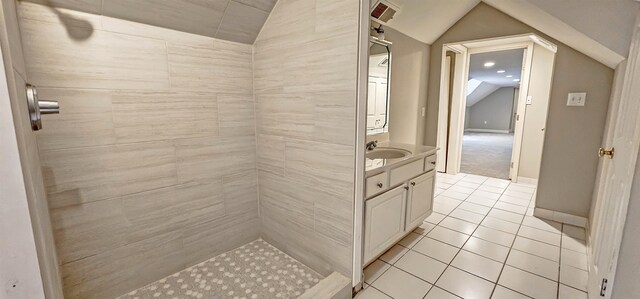 bathroom with vanity, tile patterned floors, a tile shower, and lofted ceiling