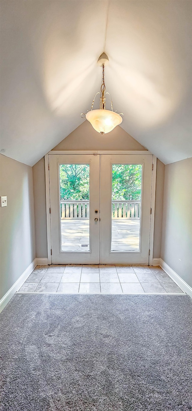 doorway with french doors, a wealth of natural light, lofted ceiling, and light carpet