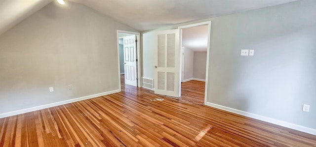 interior space featuring hardwood / wood-style floors and vaulted ceiling