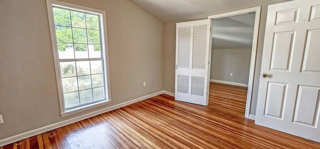 spare room with lofted ceiling and hardwood / wood-style flooring