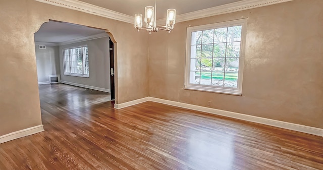 unfurnished dining area featuring ornamental molding, dark wood-type flooring, a healthy amount of sunlight, and an inviting chandelier