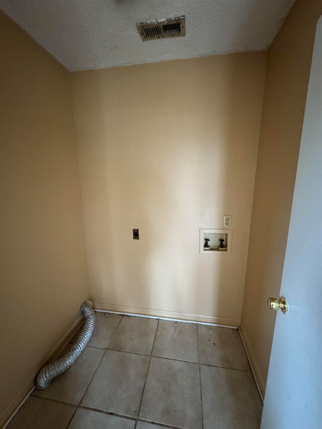 laundry room with a textured ceiling, electric dryer hookup, light tile patterned flooring, and washer hookup