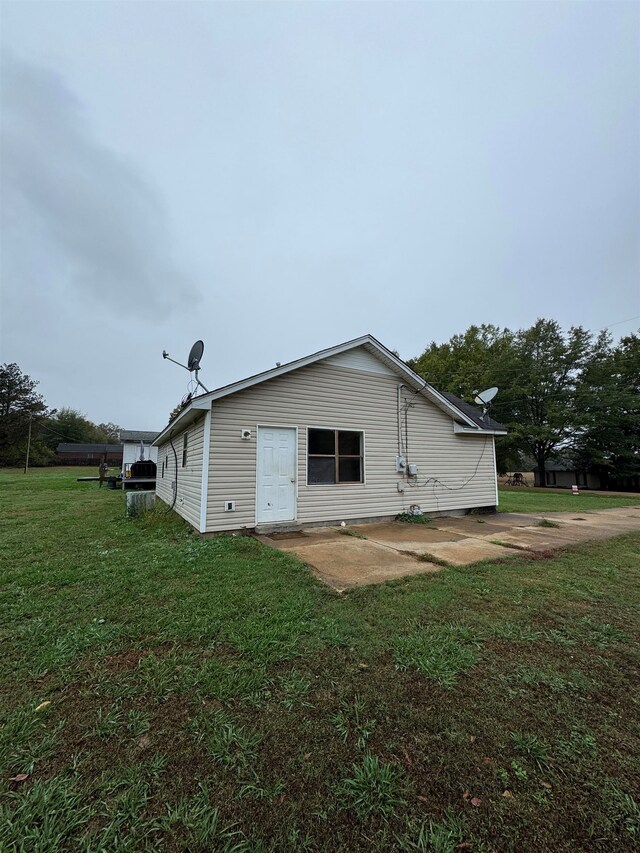 view of property exterior featuring a patio area and a lawn