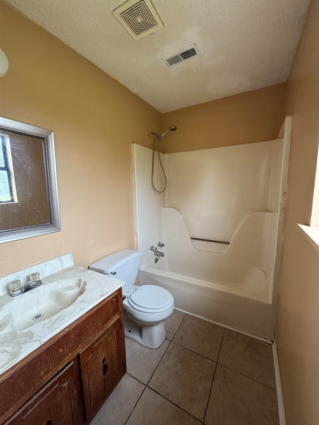 full bathroom featuring toilet, shower / bathing tub combination, a textured ceiling, and tile patterned flooring