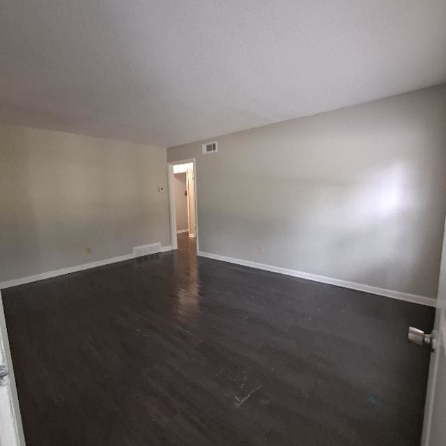 unfurnished room with dark hardwood / wood-style floors