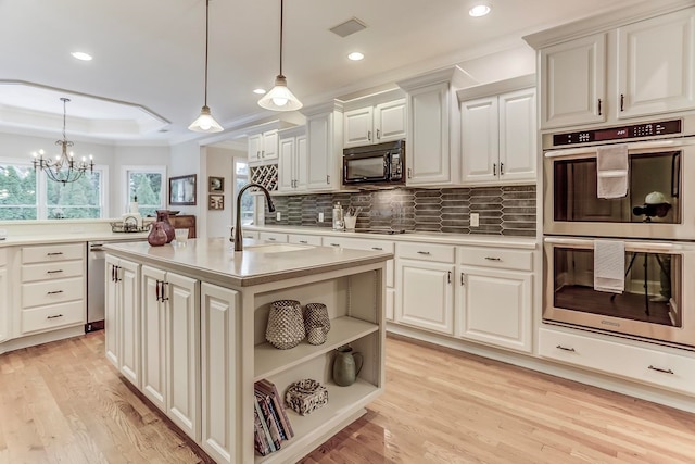 kitchen featuring white cabinetry, black appliances, a center island with sink, and decorative light fixtures