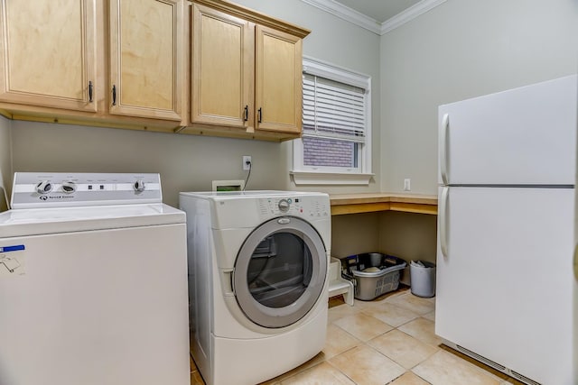 washroom with cabinets, light tile patterned flooring, washer and clothes dryer, and ornamental molding