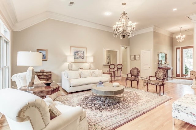 living room featuring light hardwood / wood-style floors, a chandelier, high vaulted ceiling, and ornamental molding