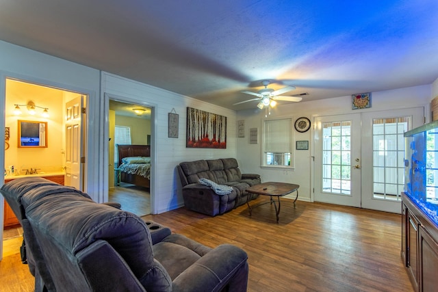 living room featuring a textured ceiling, french doors, hardwood / wood-style floors, and ceiling fan