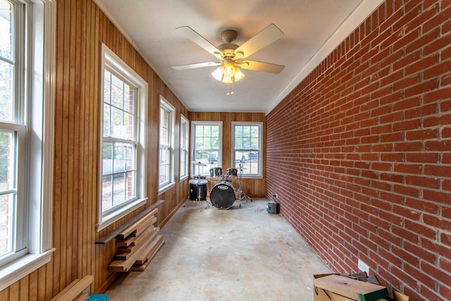 sunroom featuring ceiling fan and plenty of natural light