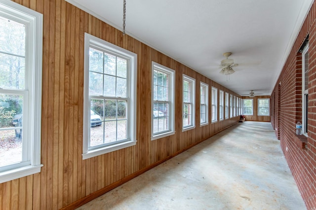 unfurnished sunroom with ceiling fan