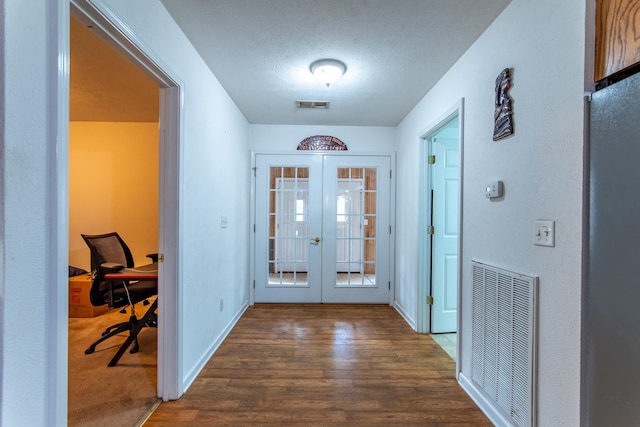 entryway with a textured ceiling, french doors, and dark hardwood / wood-style floors