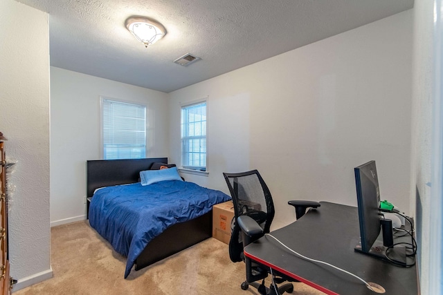 bedroom featuring a textured ceiling and light carpet