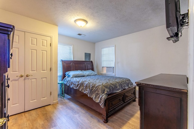 bedroom with light hardwood / wood-style floors and a textured ceiling