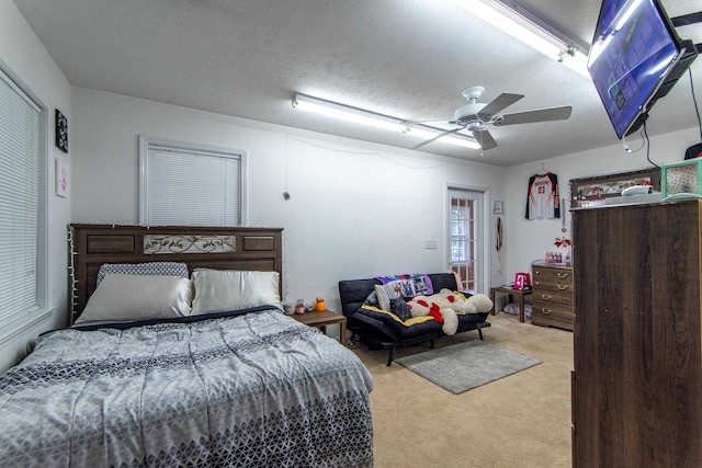 carpeted bedroom featuring a textured ceiling and ceiling fan