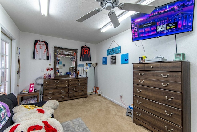 bedroom featuring a textured ceiling, light colored carpet, and ceiling fan