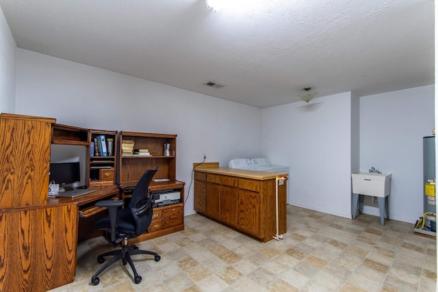 office with gas water heater, a textured ceiling, sink, and washer / clothes dryer