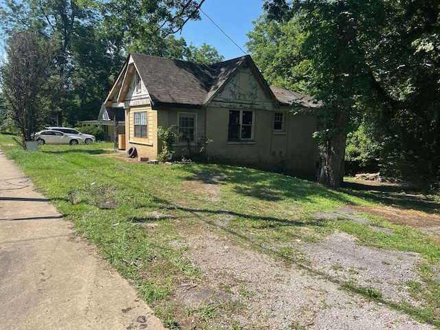 view of side of home with a lawn