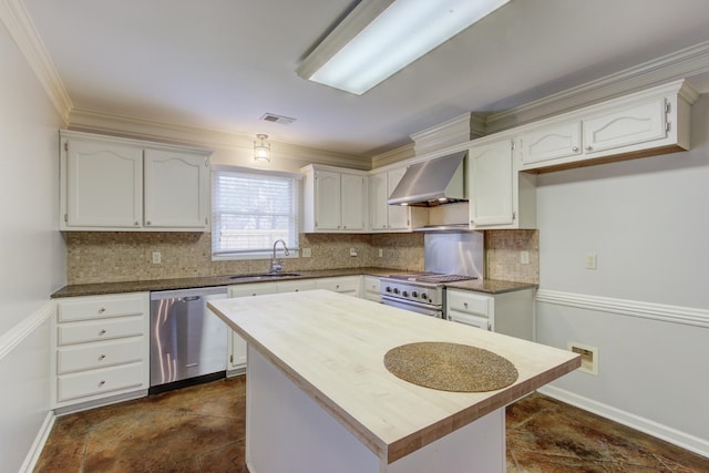 kitchen featuring stainless steel appliances, wall chimney exhaust hood, sink, crown molding, and white cabinetry