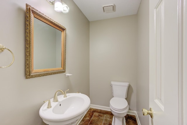 bathroom featuring toilet, sink, tile patterned floors, and a textured ceiling