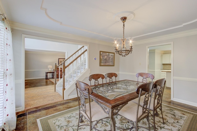 dining space featuring ornamental molding, hardwood / wood-style flooring, and a chandelier