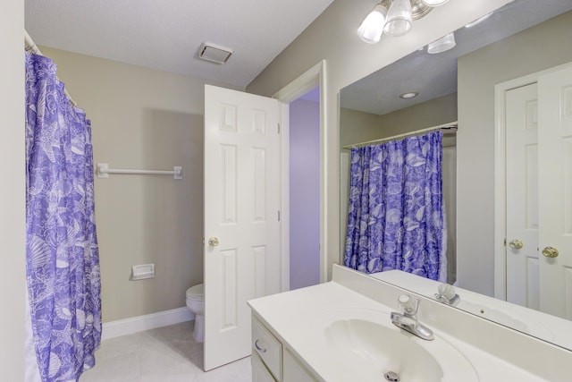 bathroom featuring toilet, vanity, a textured ceiling, and tile patterned floors