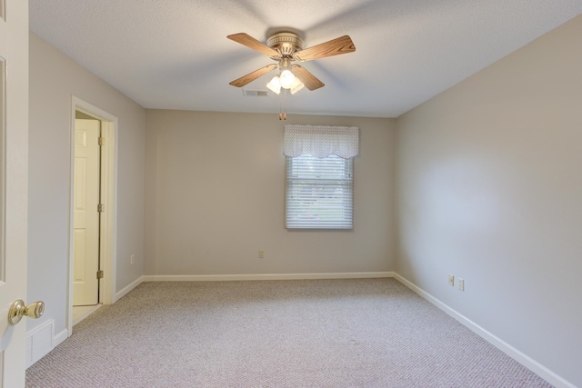 carpeted spare room featuring a textured ceiling and ceiling fan