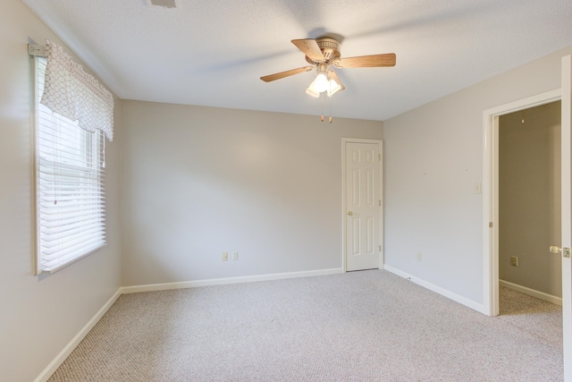 empty room featuring light colored carpet and ceiling fan