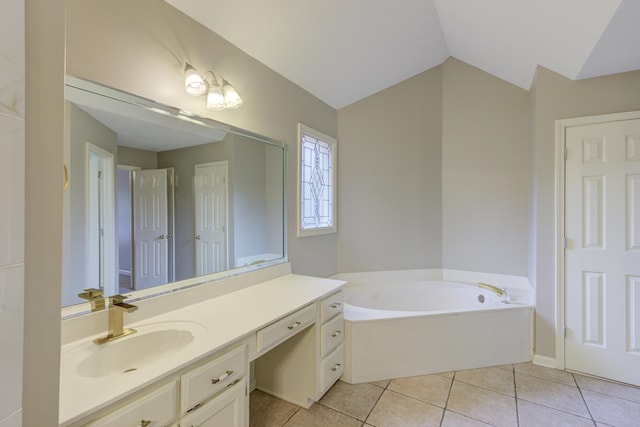 bathroom featuring a tub to relax in, vanity, vaulted ceiling, and tile patterned floors