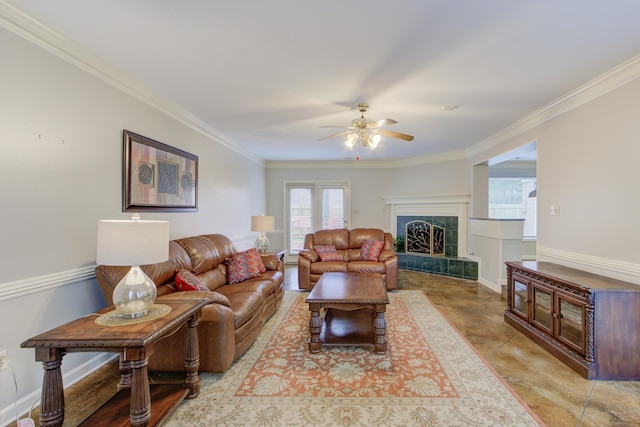 living room featuring ceiling fan, a tile fireplace, and crown molding