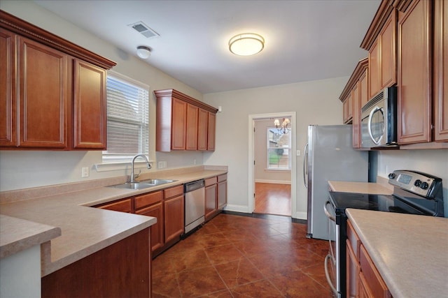 kitchen featuring a healthy amount of sunlight, sink, an inviting chandelier, and appliances with stainless steel finishes