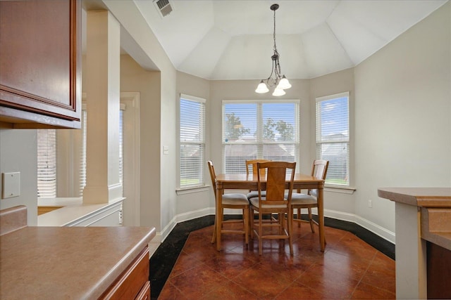 tiled dining space with vaulted ceiling and a notable chandelier