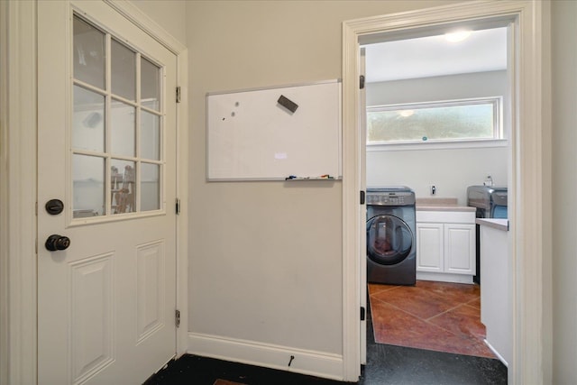 doorway with washer / clothes dryer and dark tile patterned floors