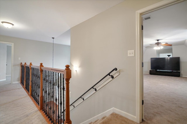 stairs with carpet flooring and ceiling fan