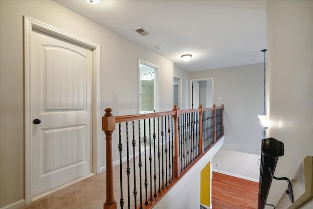 hall with light colored carpet