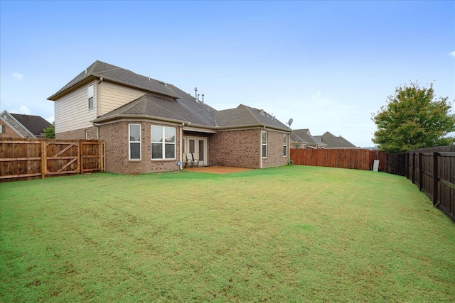 back of house featuring a lawn and a patio