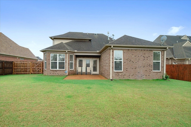 rear view of property featuring a lawn, french doors, and a patio area