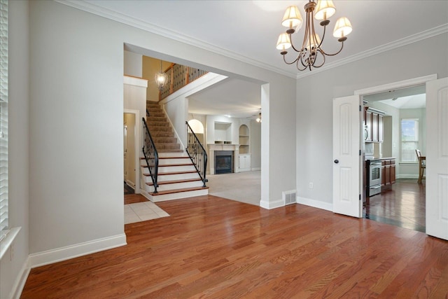 interior space featuring hardwood / wood-style floors, a chandelier, and crown molding