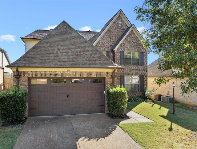 view of front facade with central AC unit, a front yard, and a garage