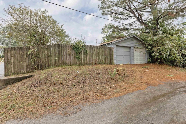 view of yard with a garage and an outbuilding